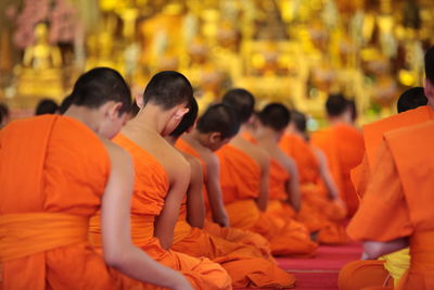 Rear view of monks sitting in rows