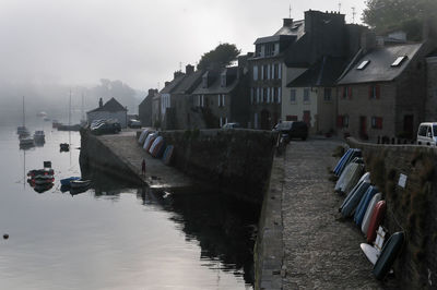 Canal amidst buildings in city against sky