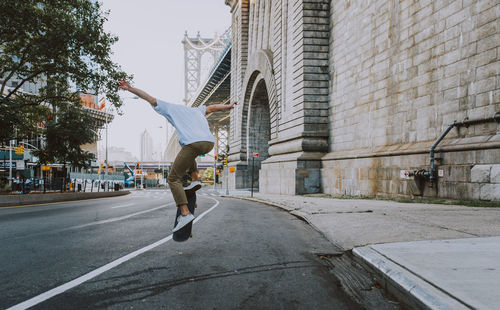 Man walking on street amidst buildings in city