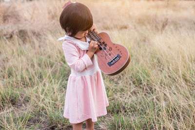 Rear view of a girl standing on field