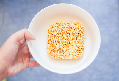 Cropped hand holding noodles bowl