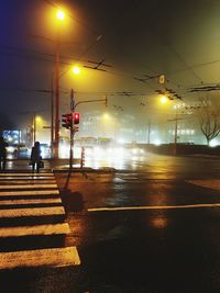 Man on illuminated street at night