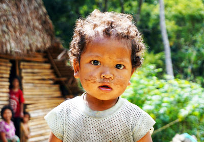 Portrait of innocent boy with dirt on face outside house during sunny day