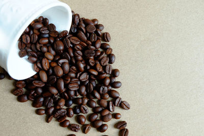 High angle view of coffee beans spilling on table