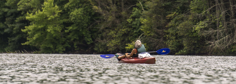 View of boat in river with trees in background