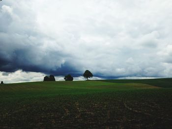 Scenic view of field against cloudy sky