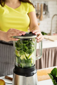 Midsection of woman making drink