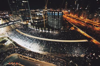 High angle view of crowd and city buildings at night