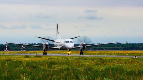 Airplane on runway against sky