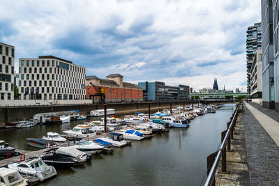 Boats moored at harbor against buildings in cologne, germany.