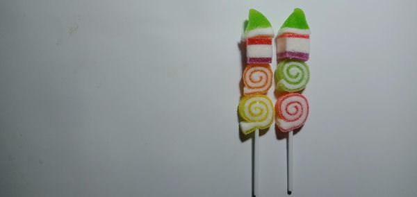 Close-up of multi colored candies on table against wall