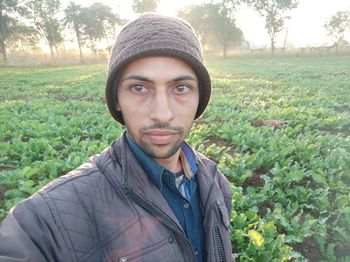 Portrait of young man standing against plants