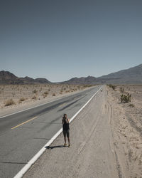 Man standing on road against clear sky