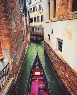 High angle view of gondolas on canal amidst buildings