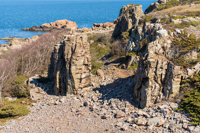 Panoramic shot of rock formation in sea against sky