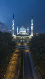 Illuminated building against sky at dusk