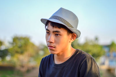 Portrait of young man looking away outdoors