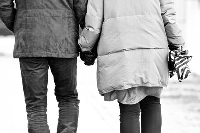 Midsection of man and woman walking outdoors