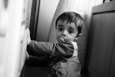 Portrait of cute baby boy sucking pacifier at home