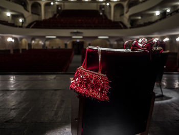 Purse and high heels on chair in auditorium