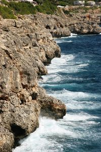 Scenic view of sea by cliff against sky