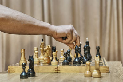 Cropped hand of man playing chess