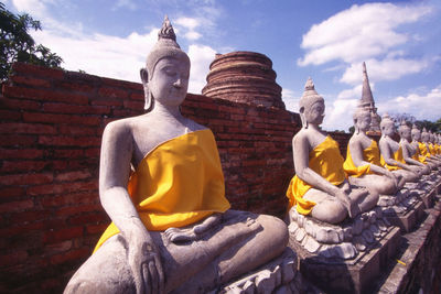 Low angle view of buddha statue against sky