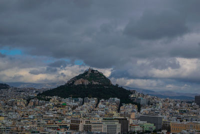 Aerial view of city against cloudy sky