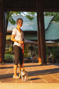 Woman owner walking with brown and white chihuahua dog.