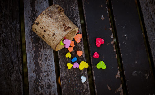 Close-up of multi colored heart shape pills spilling on table