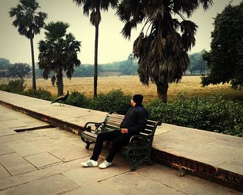 Rear view of man sitting on bench