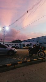 Cars on road against sky during sunset