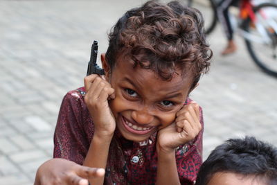 Portrait of a smiling girl holding camera