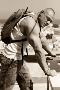 Side view portrait of muscular tourist standing at observation point