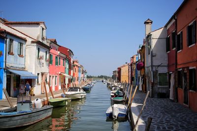 Boats in row along buildings