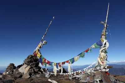 Prayer flags on mountain peak against clear blue sky
