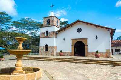 Fountain by church against sky