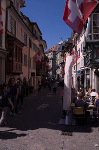 People walking on street amidst buildings in city