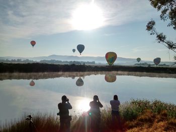 Hot air balloons flying over landscape against sky