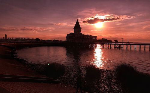 Reflection of building in river during sunset