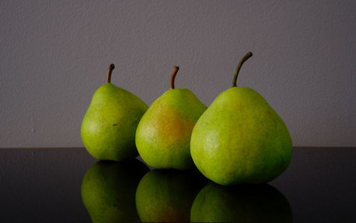 Close-up of fruits on table against wall
