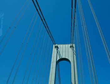 Low angle view of suspension bridge against blue sky