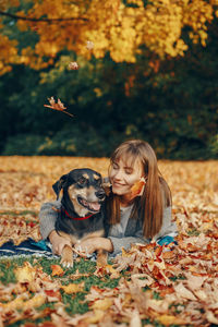 Woman with dog in autumn leaves