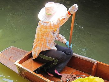 High angle view of man sitting on boat in lake