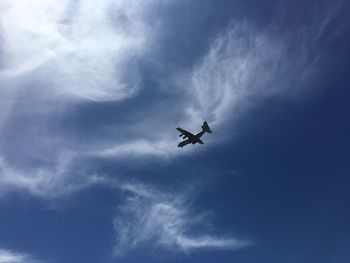 Low angle view of airplane flying against sky