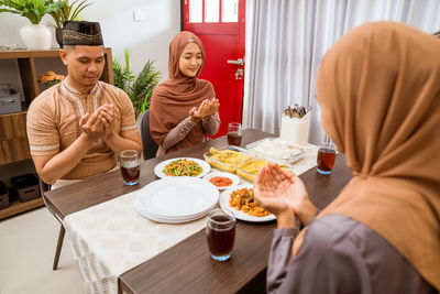 Family praying during iftar at home