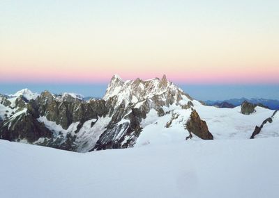 Scenic view of snowcapped mountains against sky during sunset