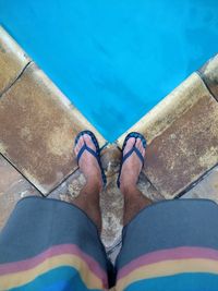 Low section of man standing by swimming pool