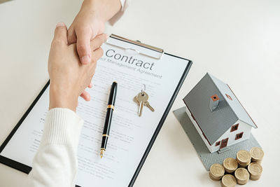 Real estate agent shaking hands with client at desk