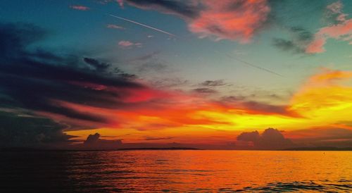 Scenic view of sea against dramatic sky during sunset